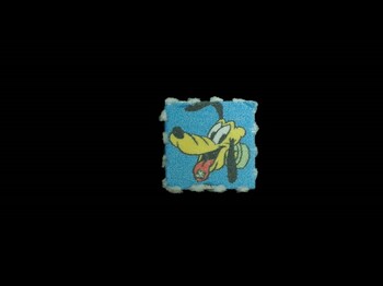 Dieses Bild zeigt einen LSD-Blotter (Logo Pluto).