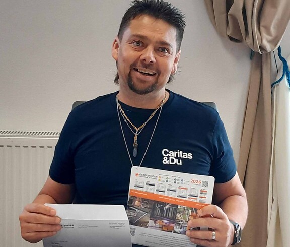 Mann kuvertiert Kalenderblatt in Briefumschlag ein