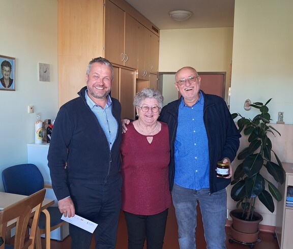 Bürgermeister Robert Tulnik gratuliert Frau Krammer herzlich zu ihrem 90. Geburtstag im Pflegewohnhaus. Frau Krammer steht in der Mitte, rechts von ihr befindet sich der Bürgermeister, links steht ein Angehöriger.