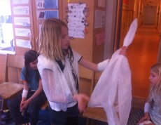 Kinder üben im Rahmen eines Erste-Hilfe-Workshops den Umgang mit Verbänden und Rettungsdecken sowie grundlegende Hilfsmaßnahmen.