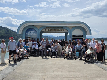 Große Reisegruppe von Haus Klara vor der Schiffsstation Klagenfurt-See am Wörthersee.