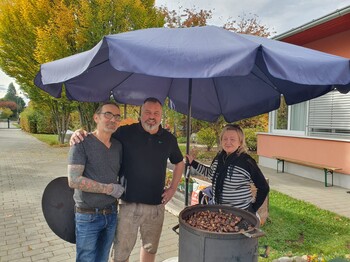 Hausleiter Josef Kurzmann steht gemeinsam mit den Maronibratern am Maroniofen.