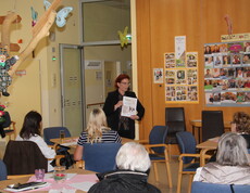 Pflegedienstleiterin Tanja Andraschko steht vor einer Gruppe interessierter Angehöriger und hält eine Rede. Sie wirkt engagiert und spricht mit Blickkontakt ins Publikum.