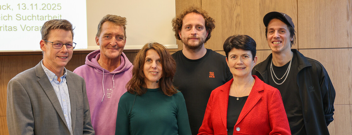 Sechs Personen stehen in zwei Reihen zu einem Gruppenfoto zusammen.