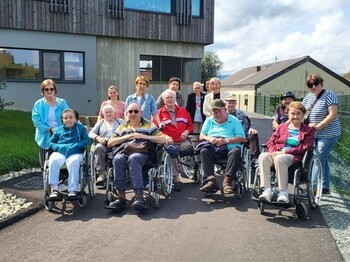 Bewohnerinnen und Bewohner des Pflegewohnhauses sitzen in Rollstühlen und machen sich gemeinsam mit Mitarbeiterinnen und Angehörigen auf den Weg zum Generationenfest der Marktgemeinde Wies.