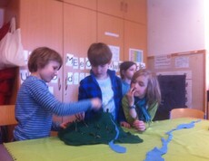 Kinder gestalten gemeinsam ein Landschaftsmodell aus verschiedenen Materialien und erkunden dabei spielerisch natürliche Lebensräume.